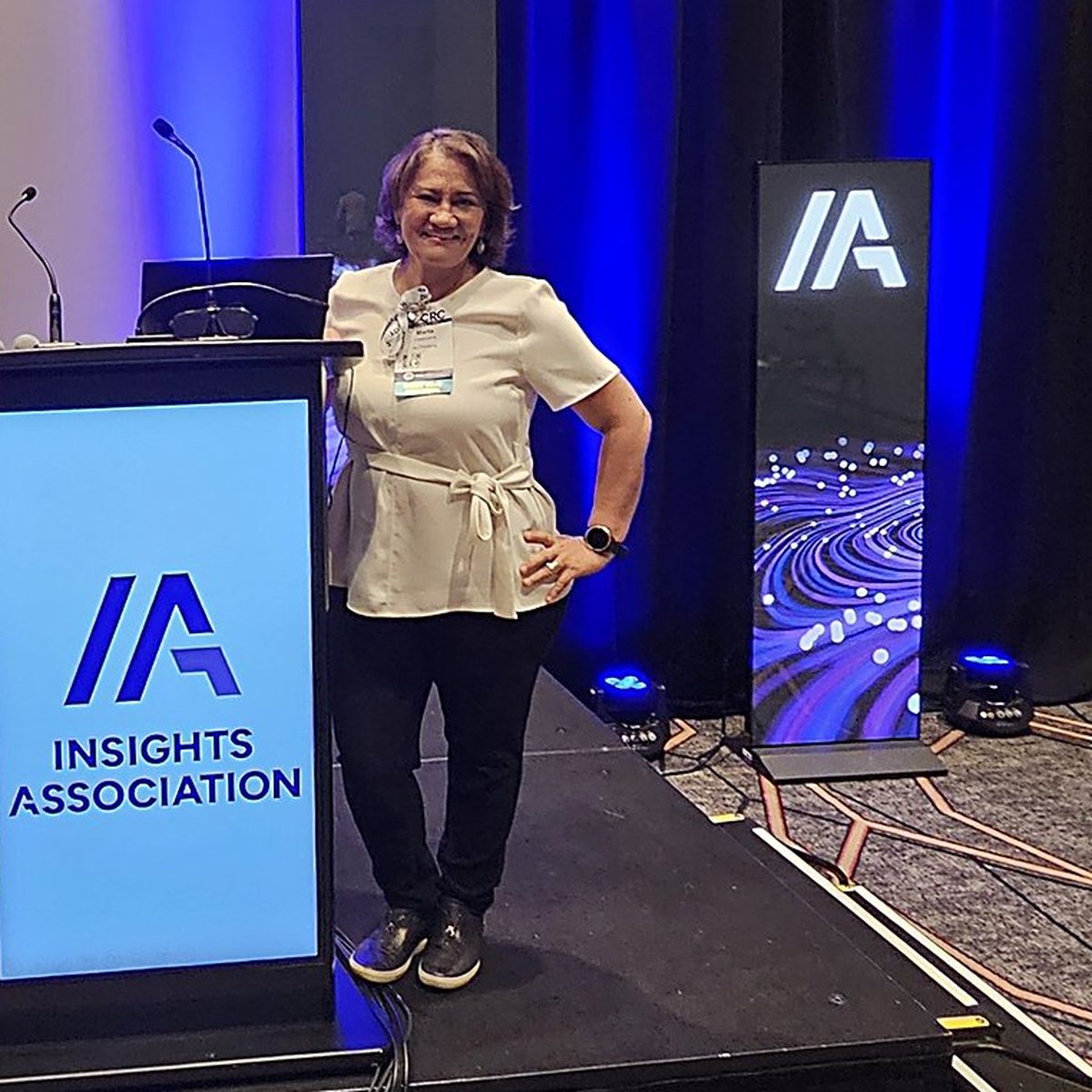 Marta Villanueva on stage beside the Insights Association podium.